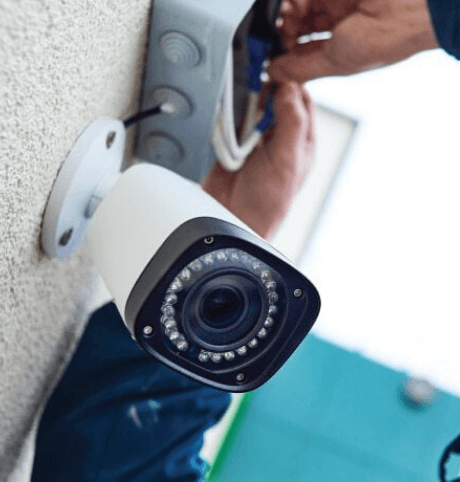 Person installing a CCTV camera - Protect Your Business with a Security System Beta Group