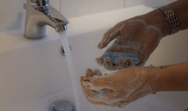 Person cleaning their hands - Returning to Work and Legionella Testing Blog