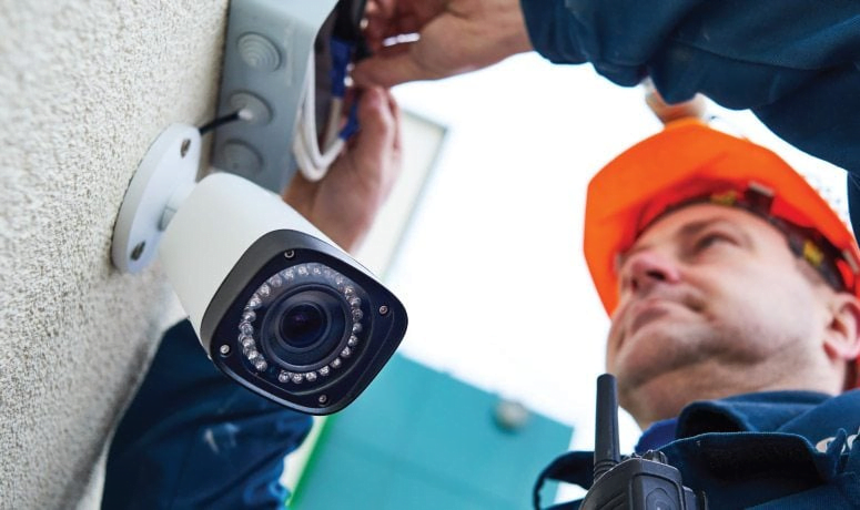 Man installing a CCTV camera - Protect Your Business with a Security System Beta Group