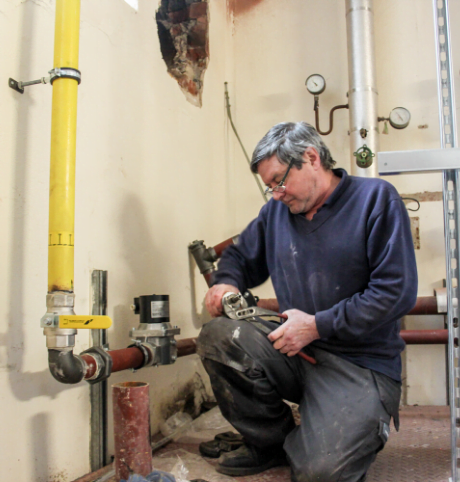 Man carrying out plumbing works - Now is the Time to Undertake Building Maintenance