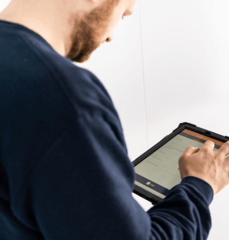 Man on handheld tablet ticking off tasks for Legionella Testing in Schools