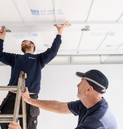 Two men changing spray booth filters